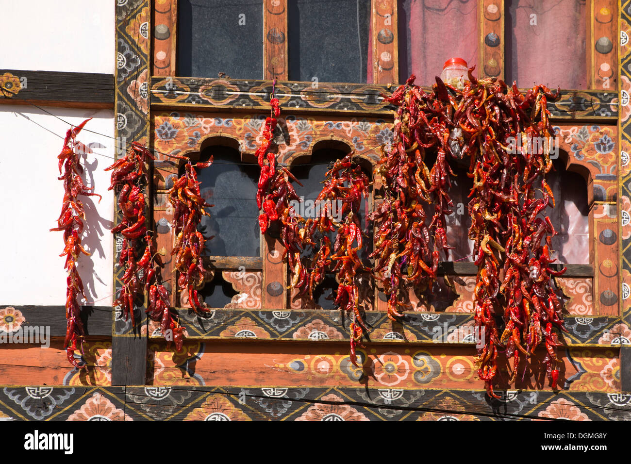 Bhután, Paro Bazar, chiles rojos de sol secado fuera tradicionalmente decorado edificio Foto de stock