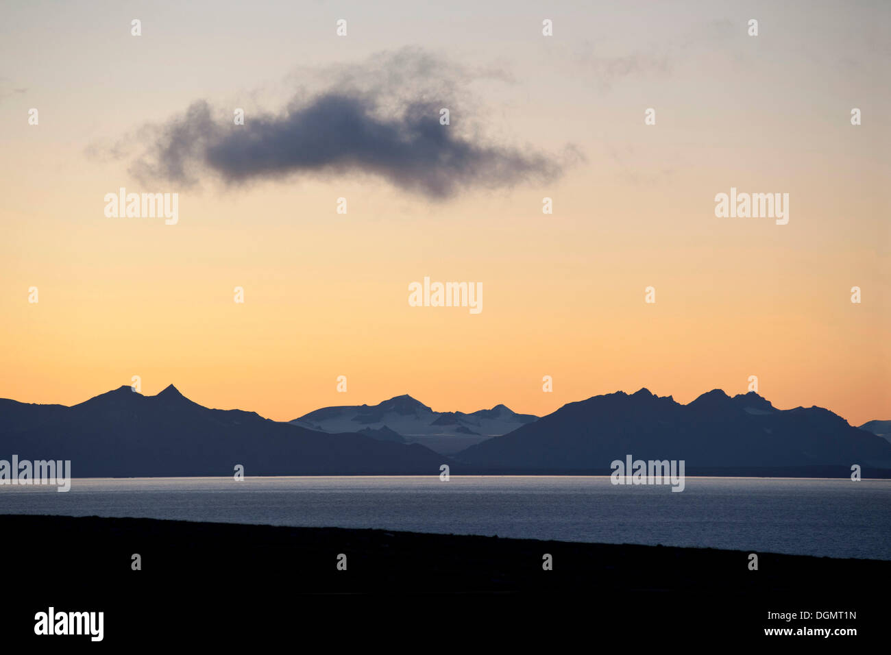 Una sola nube oscila en el crepúsculo vespertino en Isfjorden, Svalbard, Spitsbergen, Noruega, Escandinavia, Europa Foto de stock