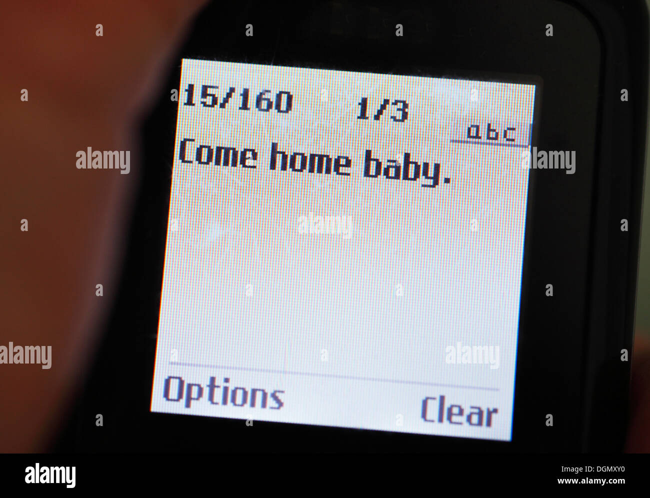 Teléfono móvil muestra el mensaje prueba 'Come home bebé". Foto de stock