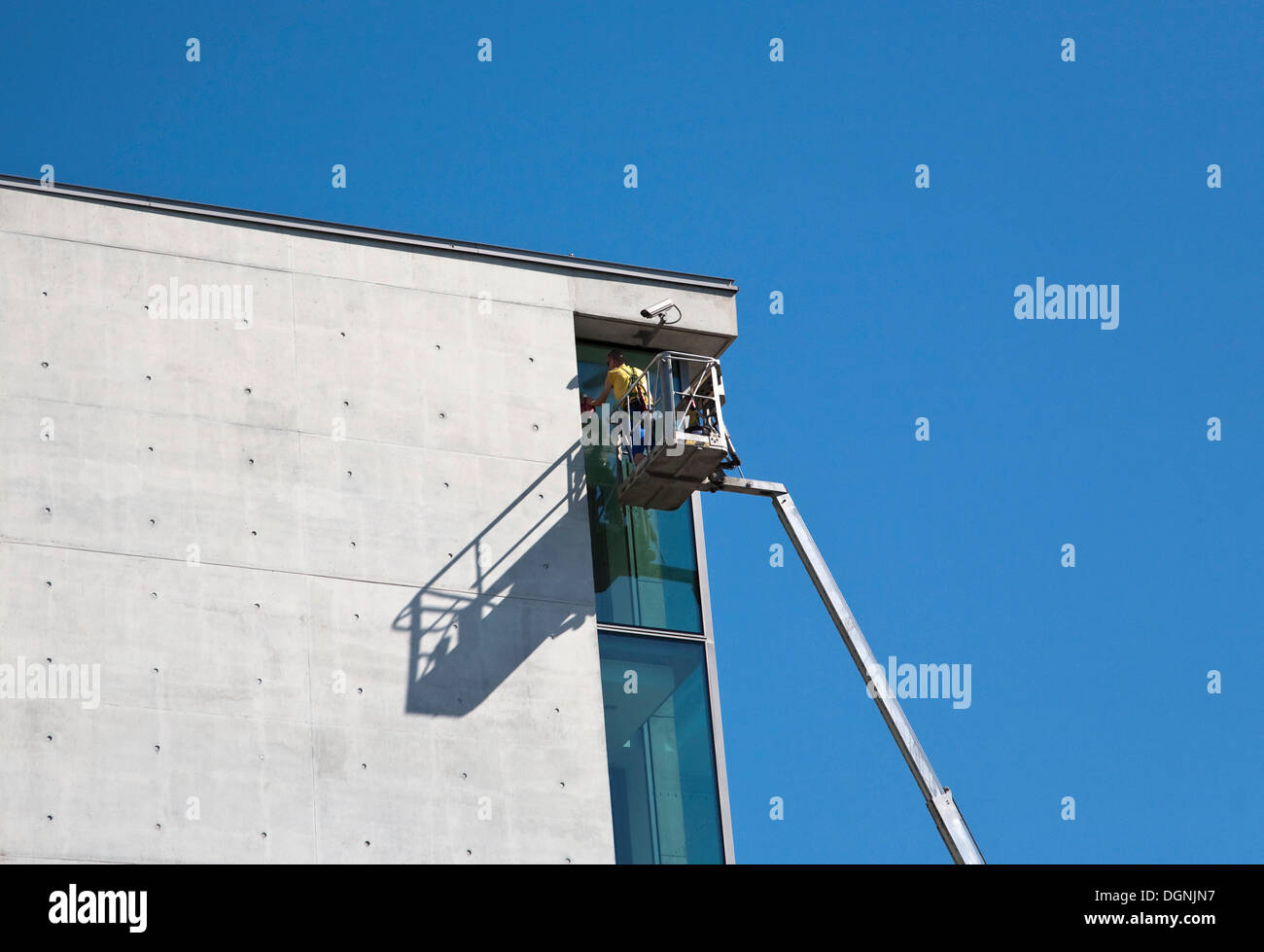 Obrero trabajando en la fachada de un complejo de oficinas en el distrito gubernamental Regierungsviertel, Berlín Foto de stock