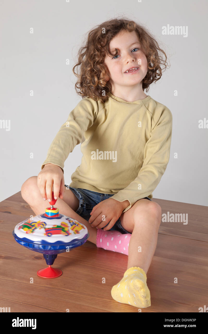 Chica pelirroja, de 5 años de edad, con un trompo Foto de stock