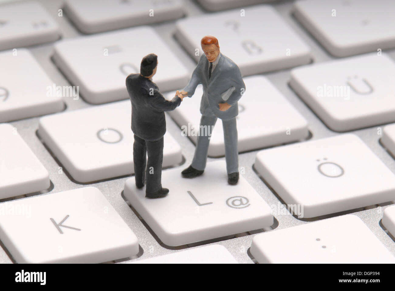 Dos hombres de negocios, figurillas, un apretón de manos en el en-clave, imagen simbólica para el comercio en Internet Foto de stock