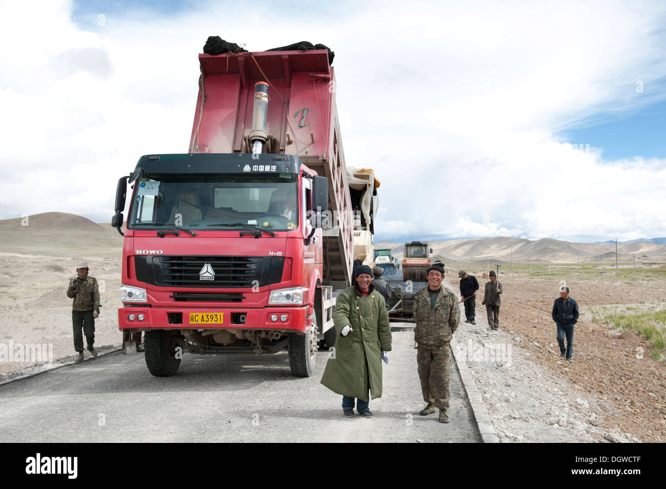 Los camiones en la construcción de carreteras a través de los Highlands tibetano, Calle G 219, supervisor en un abrigo, Trans-Himalaya, Himalaya Foto de stock