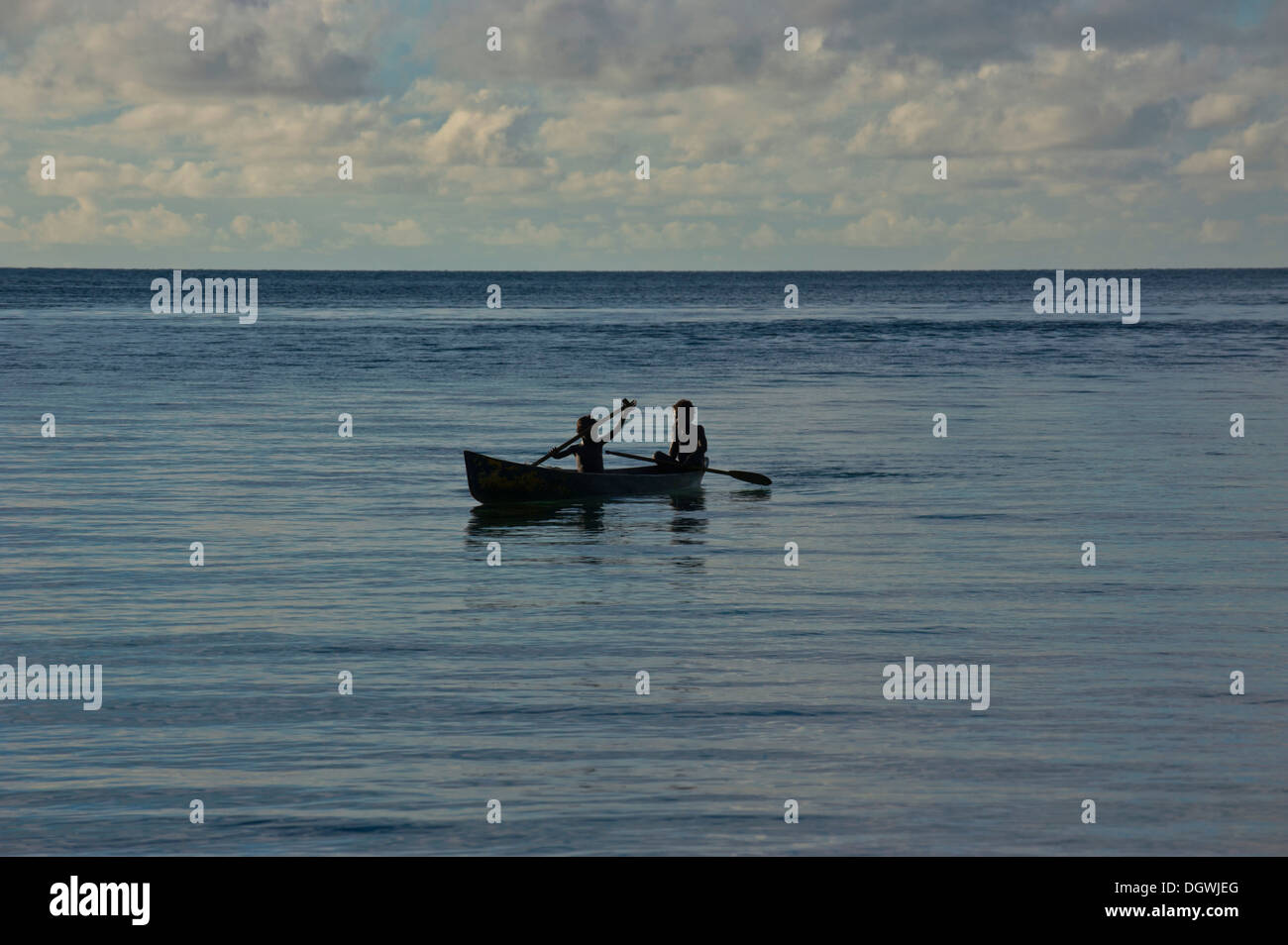 Los muchachos en una canoa en la laguna de Marovo, retroiluminación, en la provincia occidental, las Islas Salomón Foto de stock