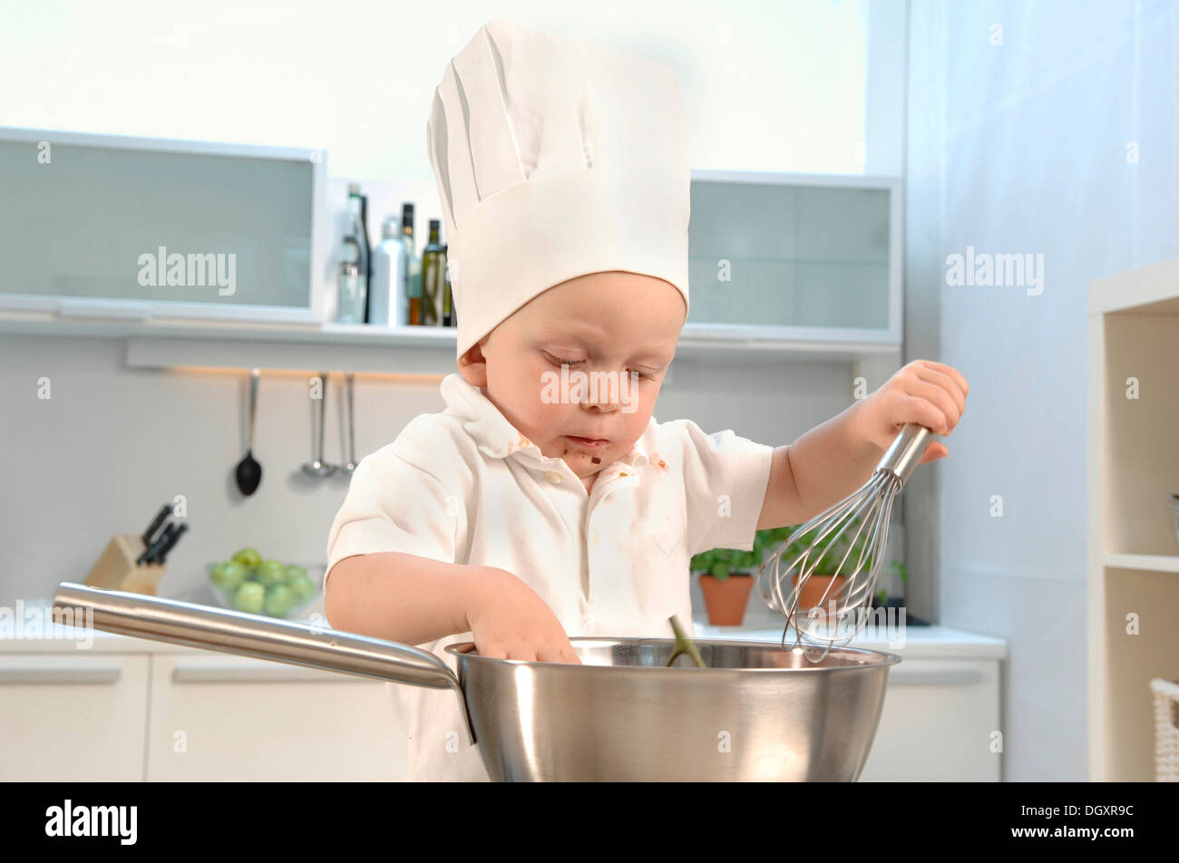 Los infantes, 2-4, vistiendo un gorro de cocinero en una cocina y  sosteniendo una bata Fotografía de stock - Alamy