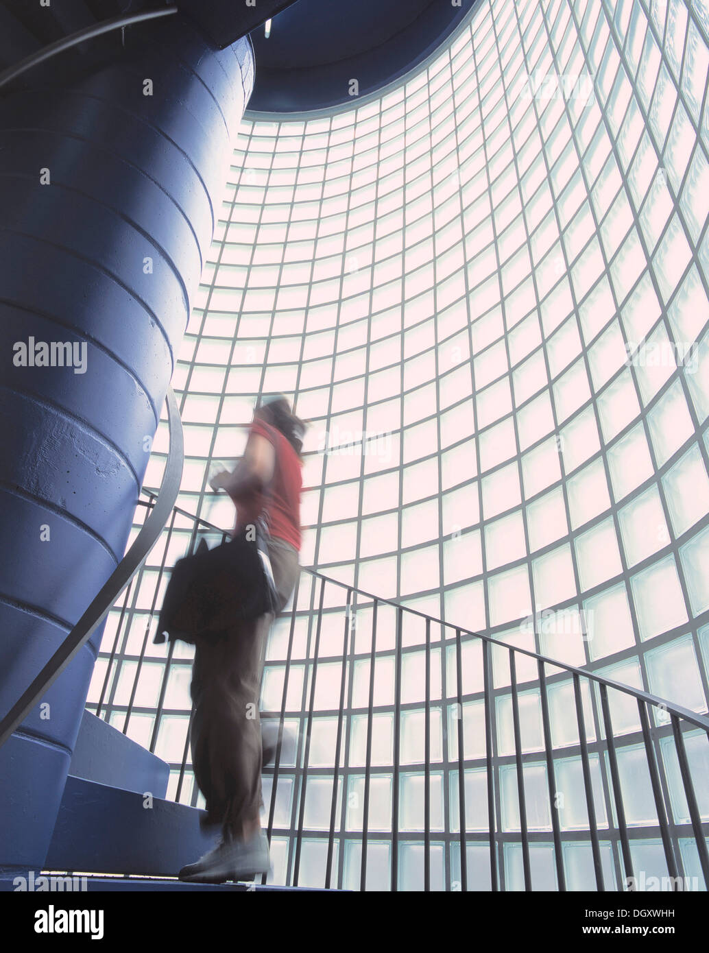 Mujer al subir las escaleras de una escalera con bloques de cristal. Foto de stock