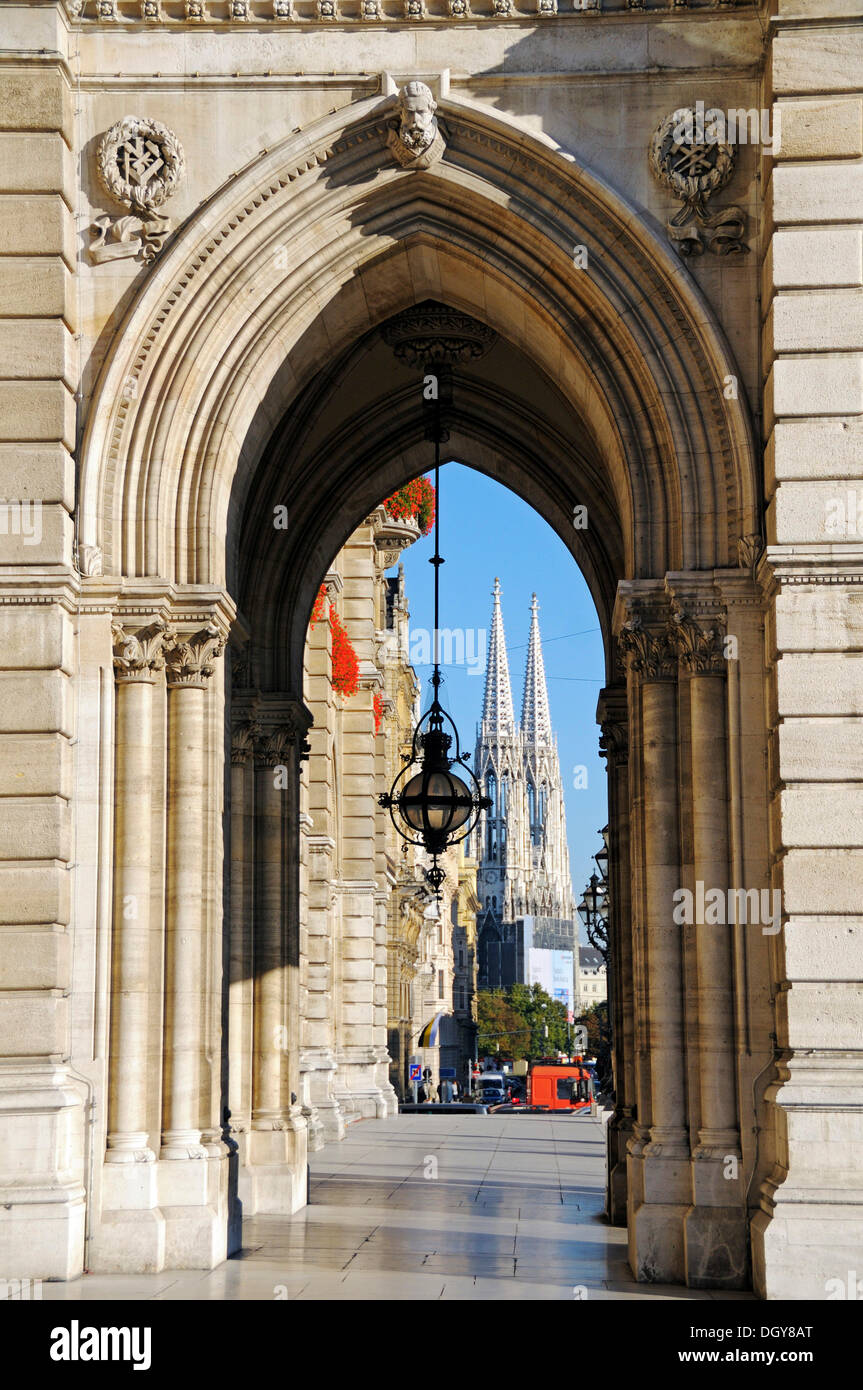 Vista a través de un arco del Ayuntamiento hacia la iglesia votiva de Viena, Austria, Europa Foto de stock