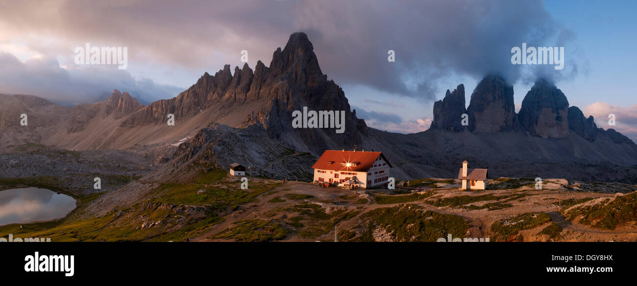 Vista panorámica con Dreizinnenhuette cabaña de montaña y capilla, vistas del monte y el Paternkofel Tre cime di Lavaredo al amanecer Foto de stock