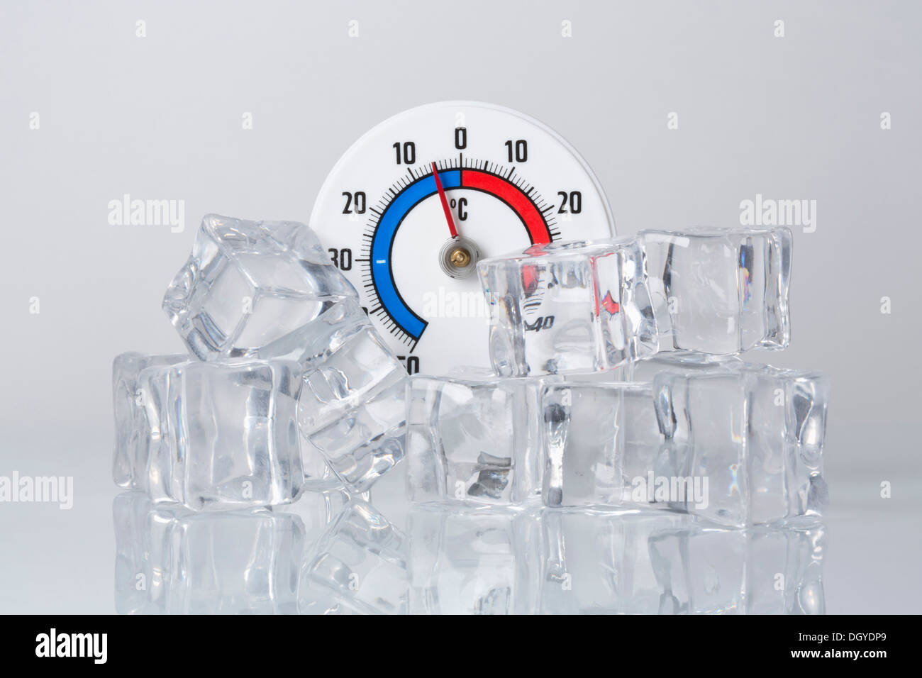 Un termómetro Celsius detrás de un montón de cubitos de hielo. Foto de stock