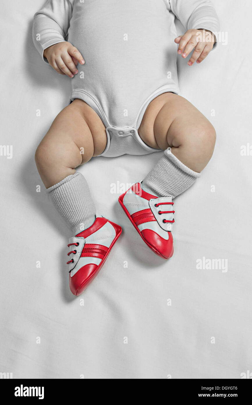 Un bebé bebé niño usando zapatos de de la cintura hacia abajo Fotografía de stock - Alamy