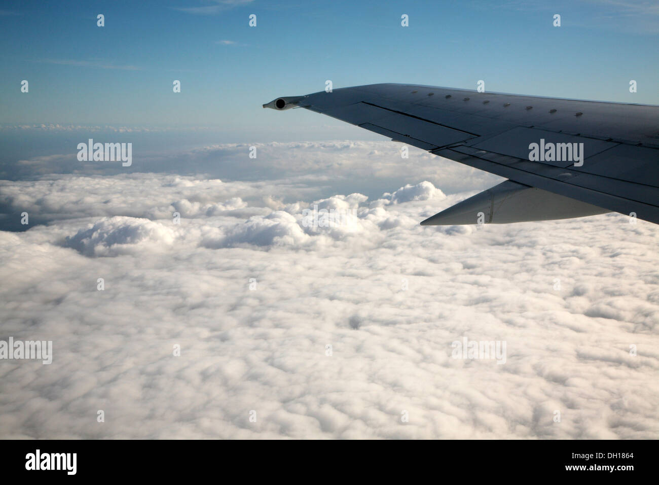Mirando en la ventana de ala de avión y las nubes debajo Foto de stock