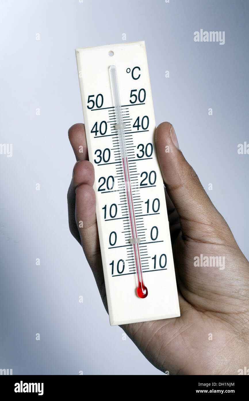 Mostrar medidor de temperatura de 35 grados centígrados cerca del medidor de temperatura sosteniendo en la mano el Sr.#743AB Foto de stock