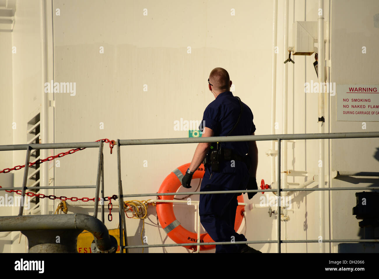 Un miembro de la tripulación de la Guardia Costera del Río Columbia Sector buque embarque inspecciona el equipo de seguridad de la superestructura de un buque de carga de seguridad de la guardia costera durante el embarque en el Río Columbia fuera de Astoria, Oregon, 21 de octubre de 2013. Un seis-hombre rendezvou embarque del equipo Foto de stock