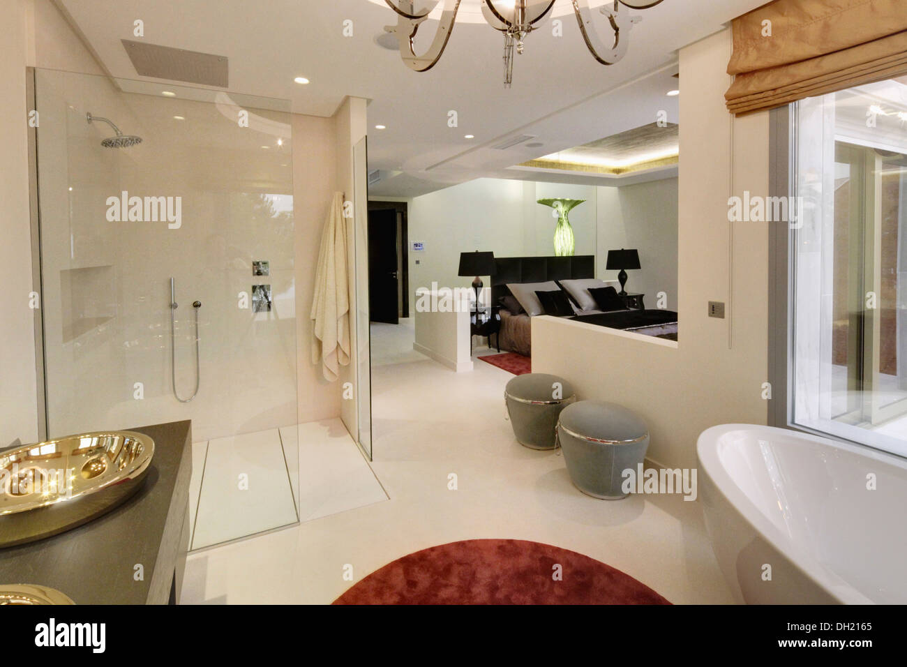 Ducha grande y gris de las heces en el diáfano, baño en-suite en español moderno apartamento dormitorio Foto de stock