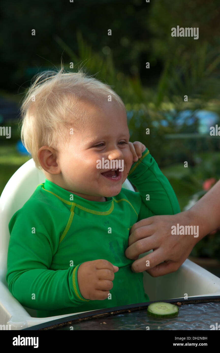 Un niño sonríe cuando se hace cosquillas en su vientre Foto de stock