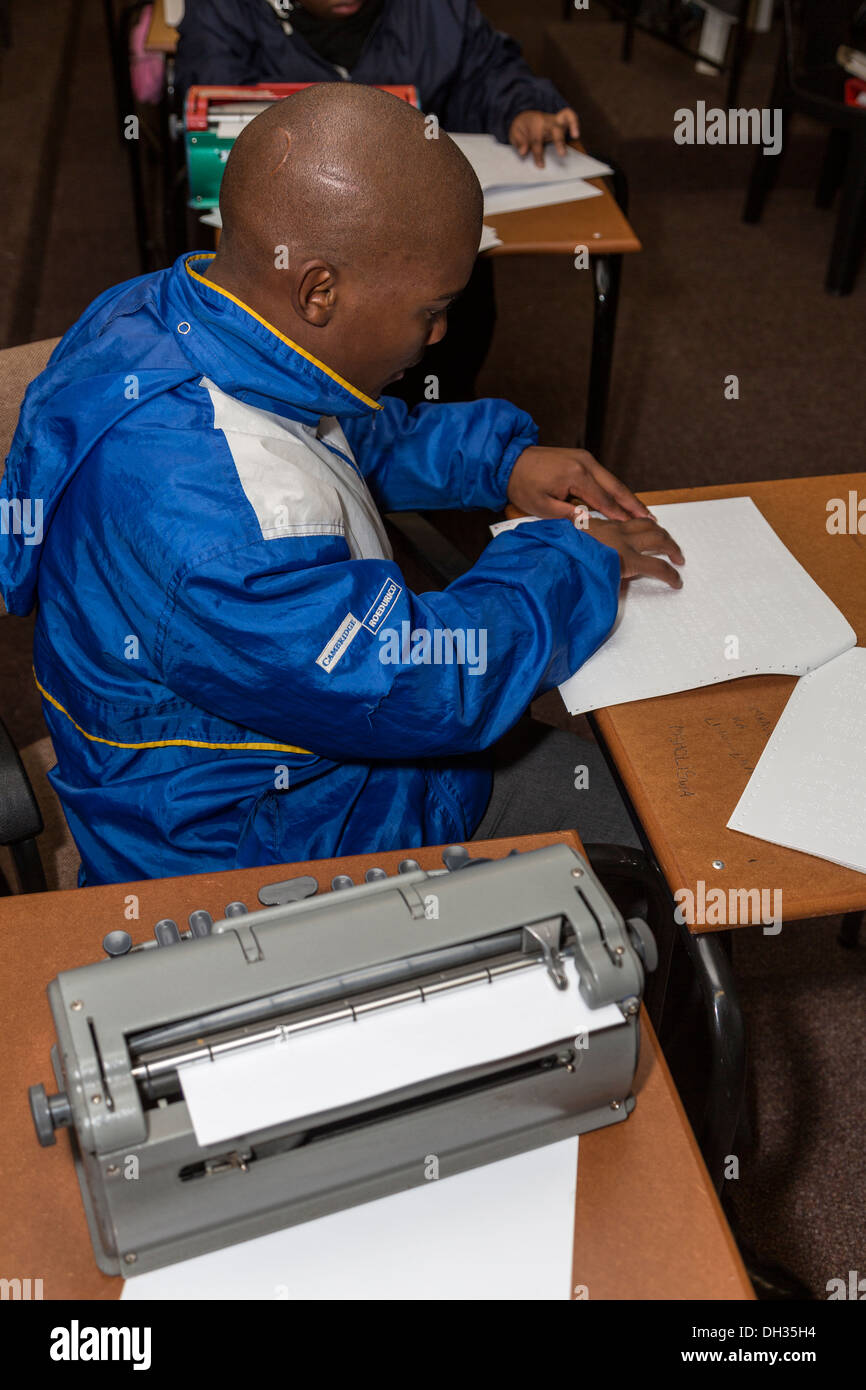 Sudáfrica, Cape Town. Estudiante Ciego leer Braille. Un Perkins Brailler Printer está en primer plano. Foto de stock