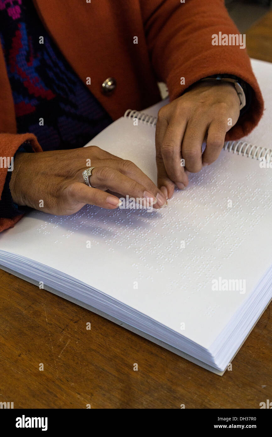Sudáfrica, Cape Town. Editor utilizando las yemas de los dedos para leer un libro de estudiante en Braille. Athlone Escuela para ciegos. Foto de stock