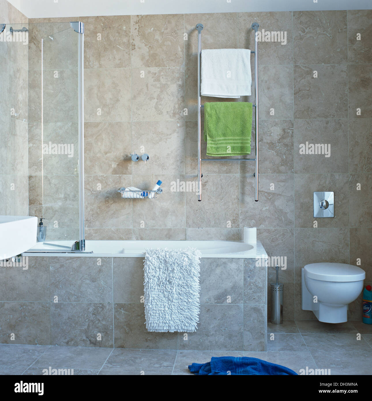 Calienta toallas en rampa de cromo en pared sobre la bañera con