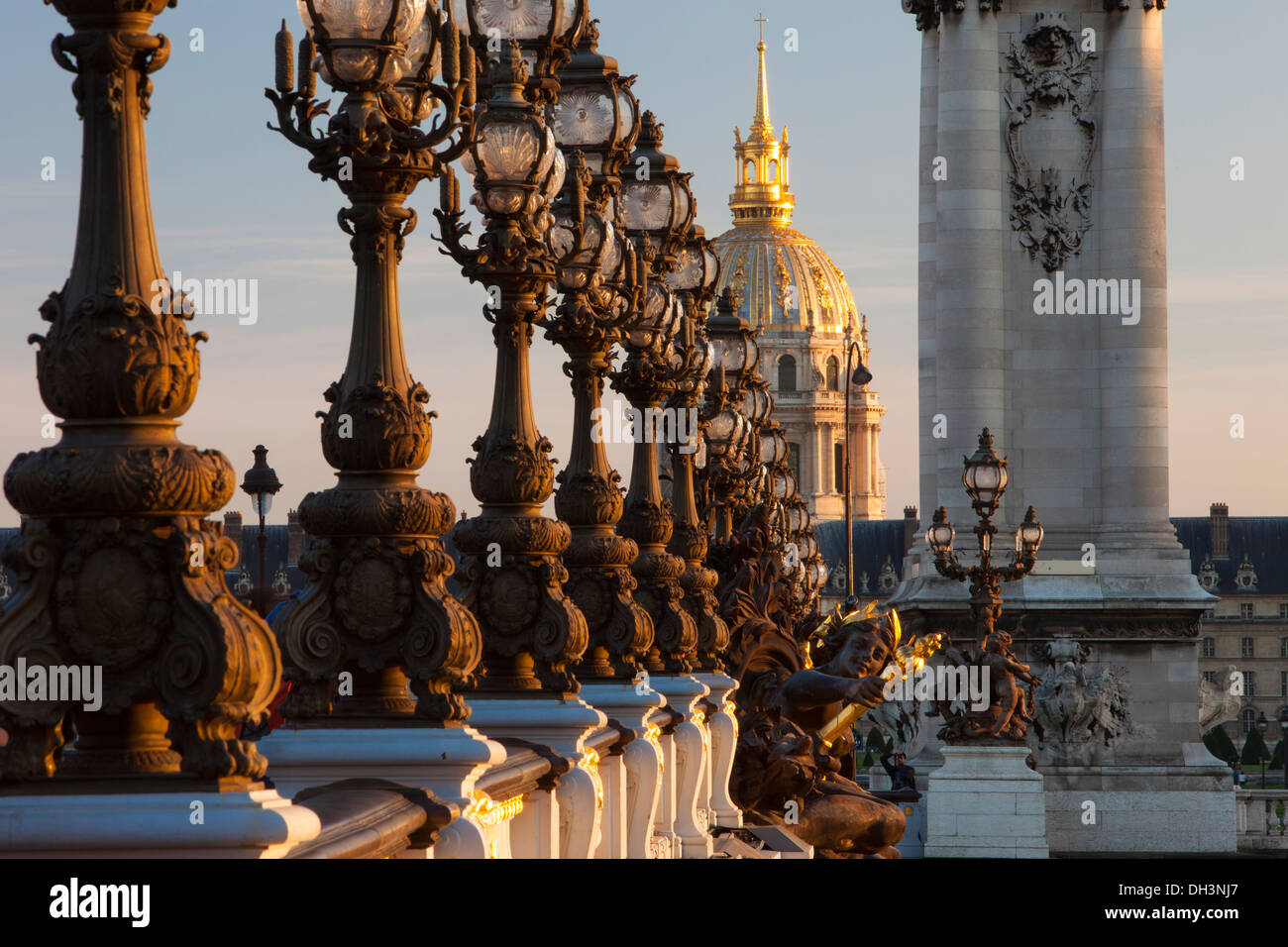 Lámparas adornadas por Puente Alexandre III con la cúpula del Hotel des Invalides más allá, París Francia Foto de stock