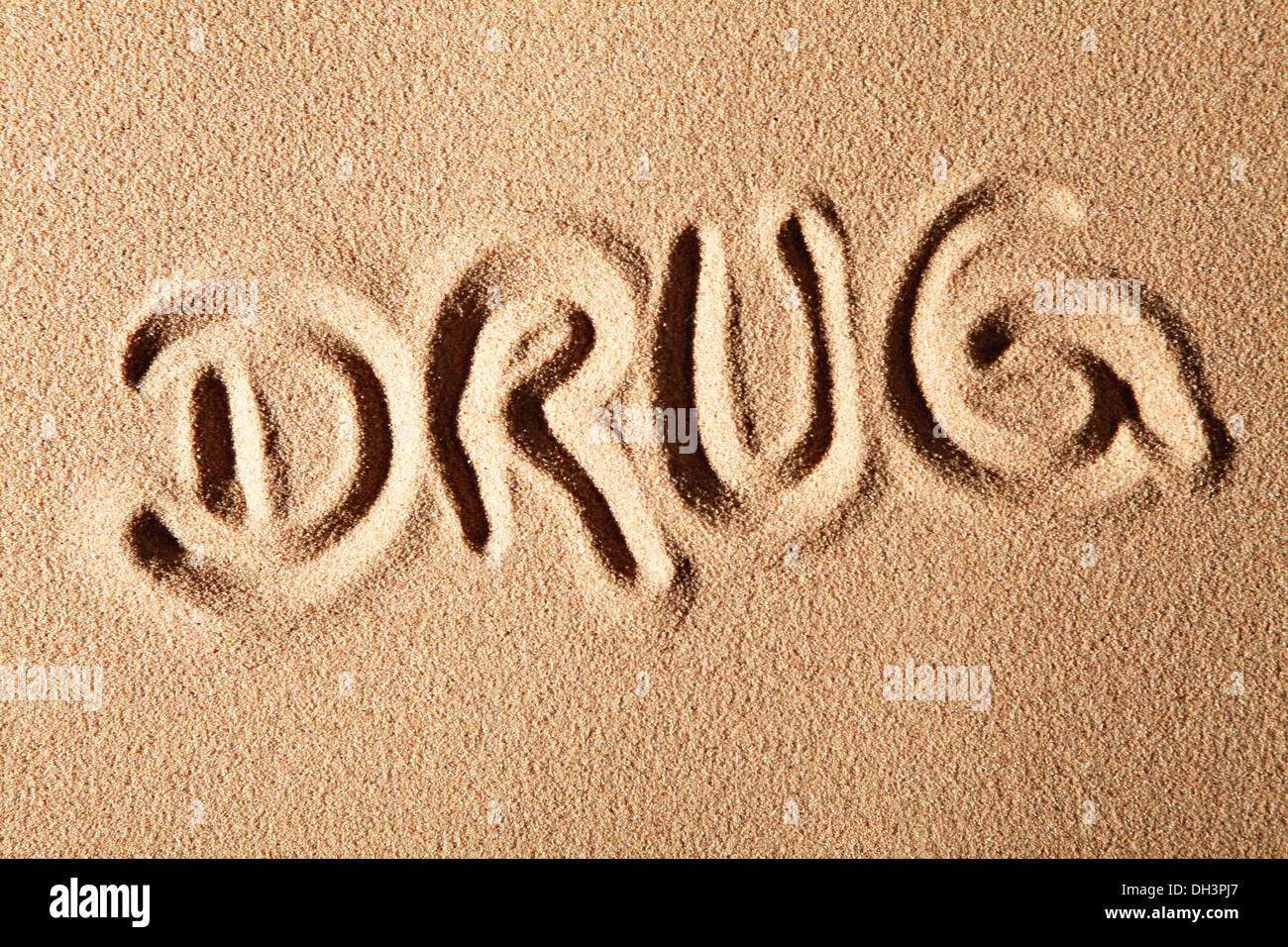 La palabra droga, dibujado en la arena Foto de stock