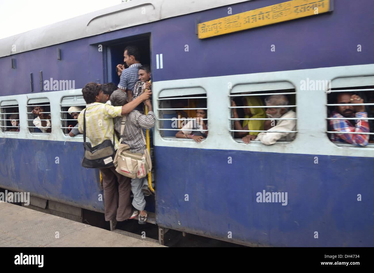 Hombres de pie sobre los escalones del tren en circulación Jodhpur Rajastán India Asia Foto de stock