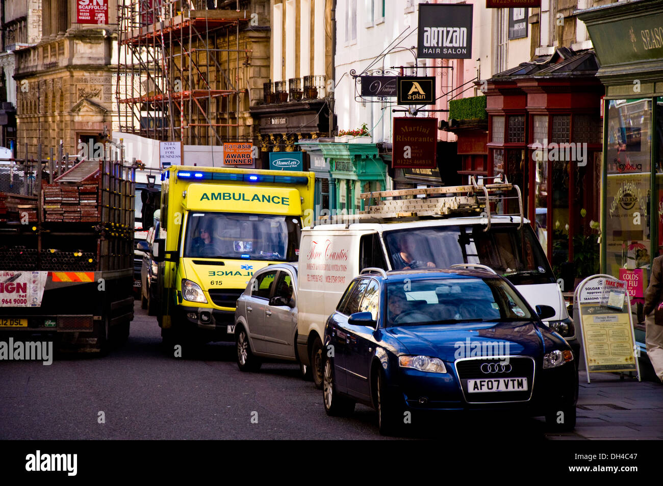 Llamada de emergencia ambulancia en intentar exprimir a través de tráfico congestionado en una concurrida calle de Bath Somerset Inglaterra Foto de stock