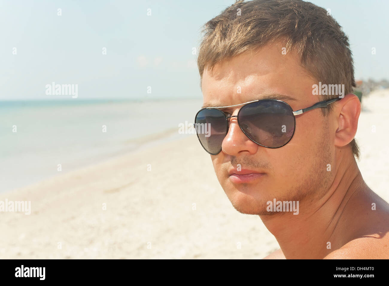 Chico en llevar gafas negras en la playa Foto de stock