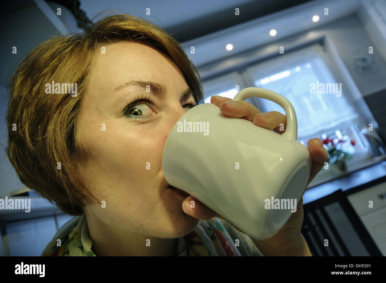 Mujer joven bebiendo café con entusiasmo Foto de stock