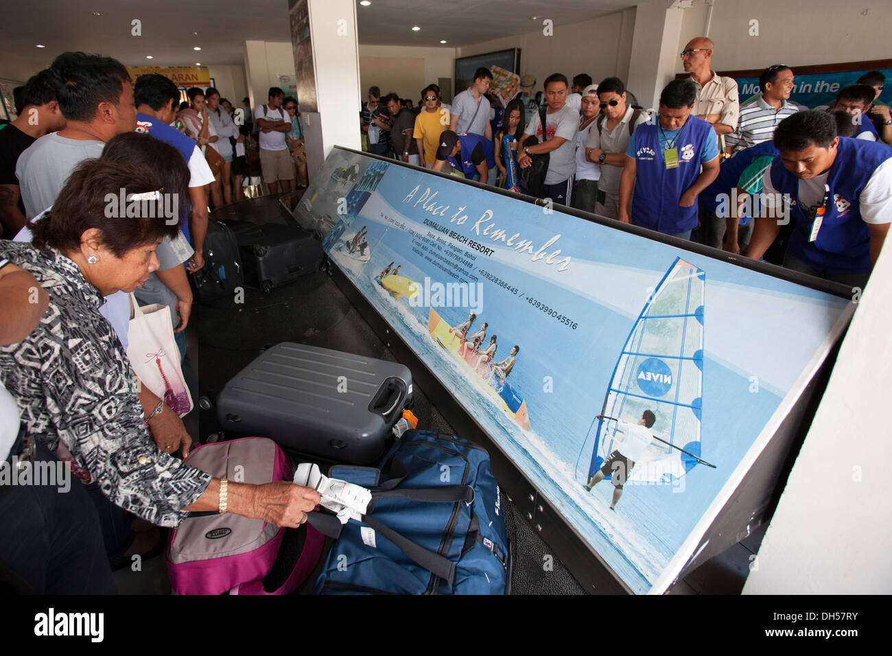 Los viajeros recoger su equipaje en la cinta de equipajes en el Aeropuerto de Tagbilaran en Bohol, Filipinas. Foto de stock