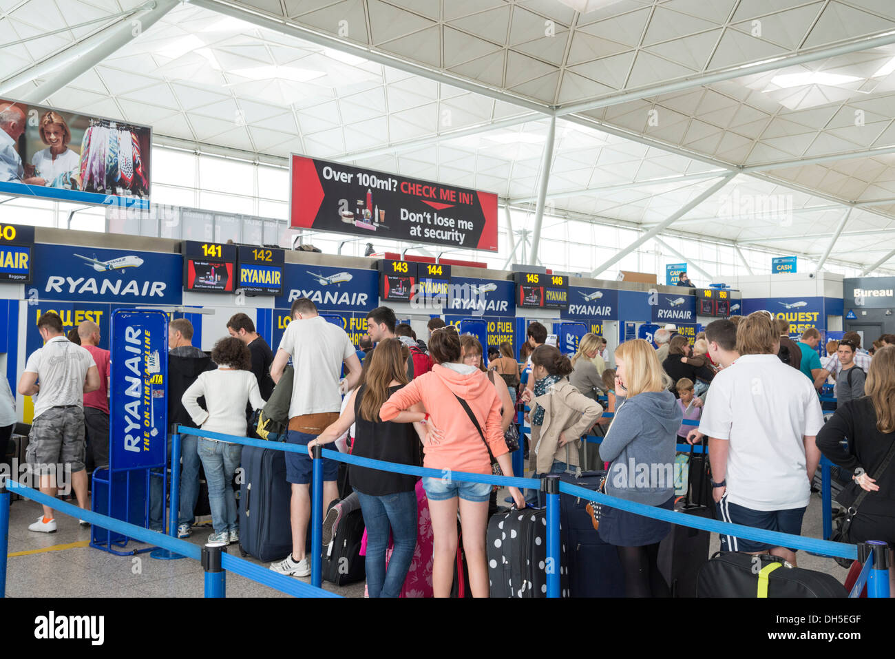 Personas haciendo cola en el check-in de Ryanair y de equipaje en el aeropuerto de Stansted, Inglaterra, Reino Unido. Foto de stock