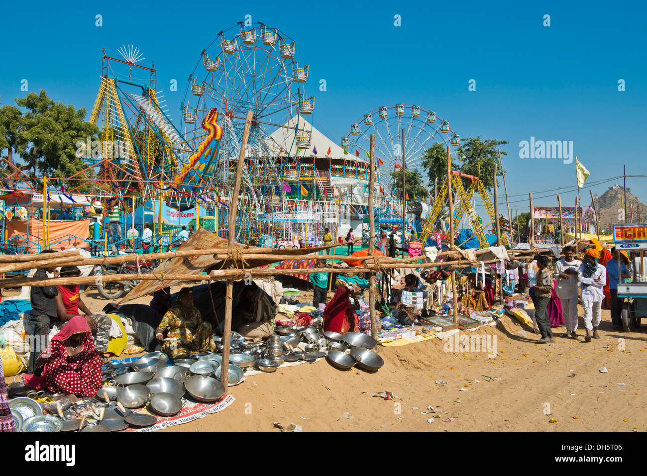 Puestos de venta de ollas y sartenes, Chapati carnaval con ruedas de Ferris en la espalda, camello Feria de Pushkar, Pushkar, Rajastán, India Foto de stock