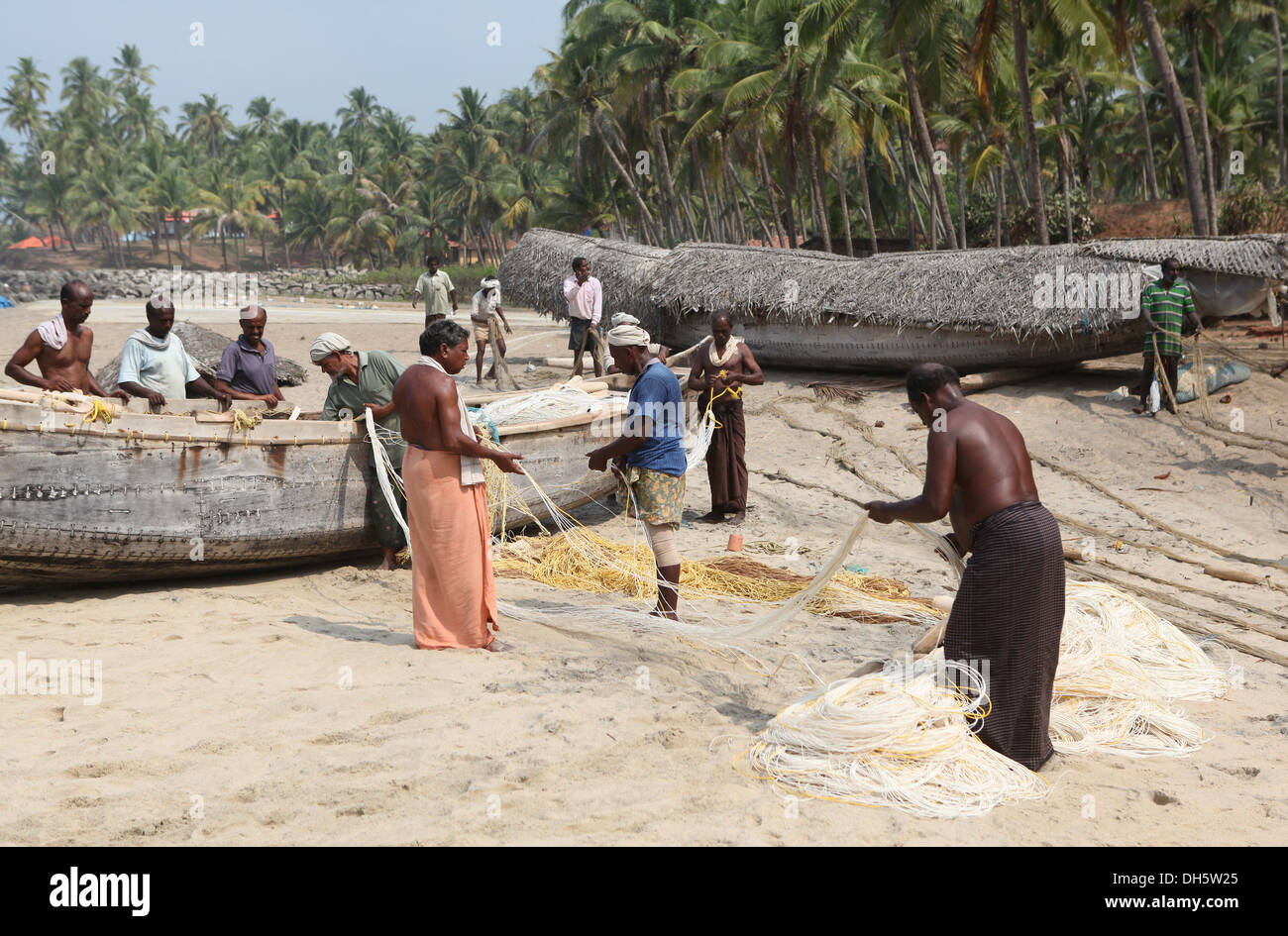 Grupo de pescadores ordenar sus redes en la playa, Varkala, Kerala, India, Asia Foto de stock