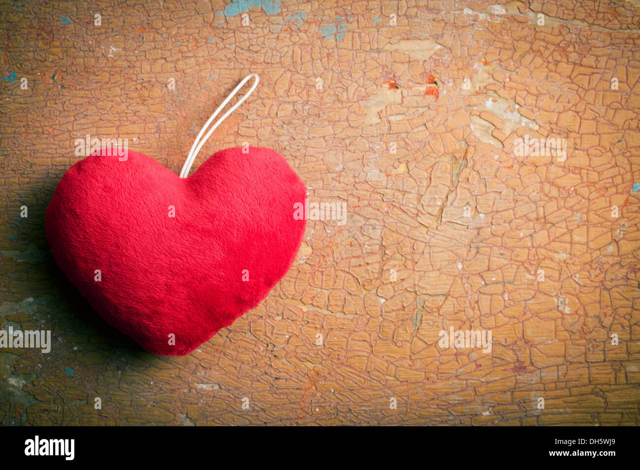 Vista superior del corazón peludo rojo sobre el antiguo fondo agrietado Foto de stock