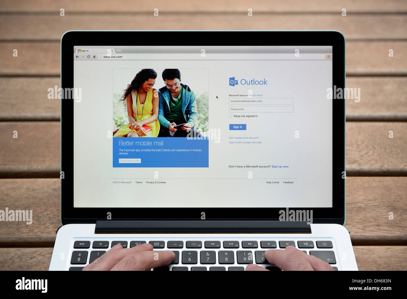 El sitio web de Windows Live en un MacBook contra un banco de madera de fondo al aire libre incluyendo un hombre de dedos (uso Editorial solamente). Foto de stock