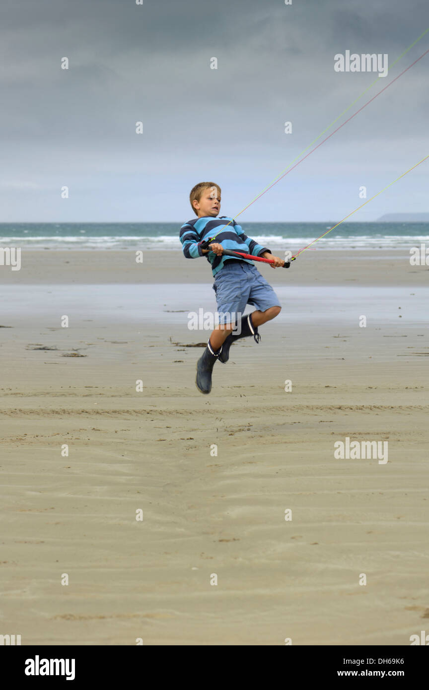 Niño volando una cometa en el remolque Atlantic Beach, Finisterre, Bretagne, Bretaña, Francia, Europa, publicground Foto de stock