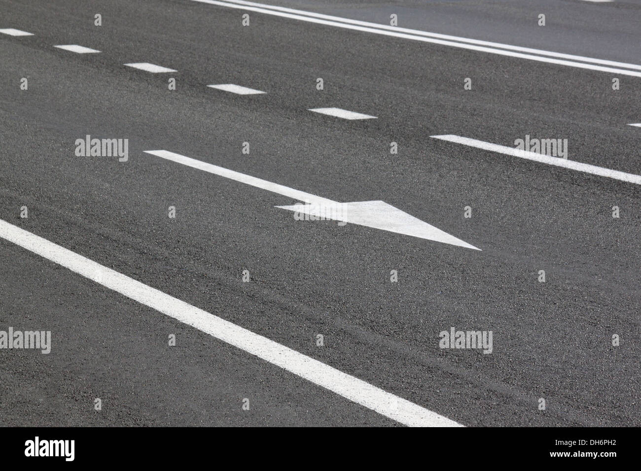 Las líneas divisorias y la flecha en la carretera Foto de stock