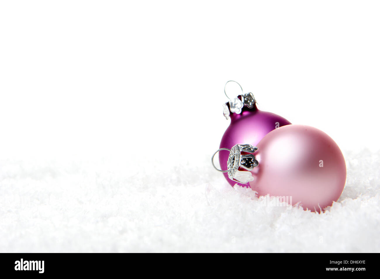 Ornamento de Navidad, bolas de navidad en rosa con fondo blanco nieve artificial Foto de stock