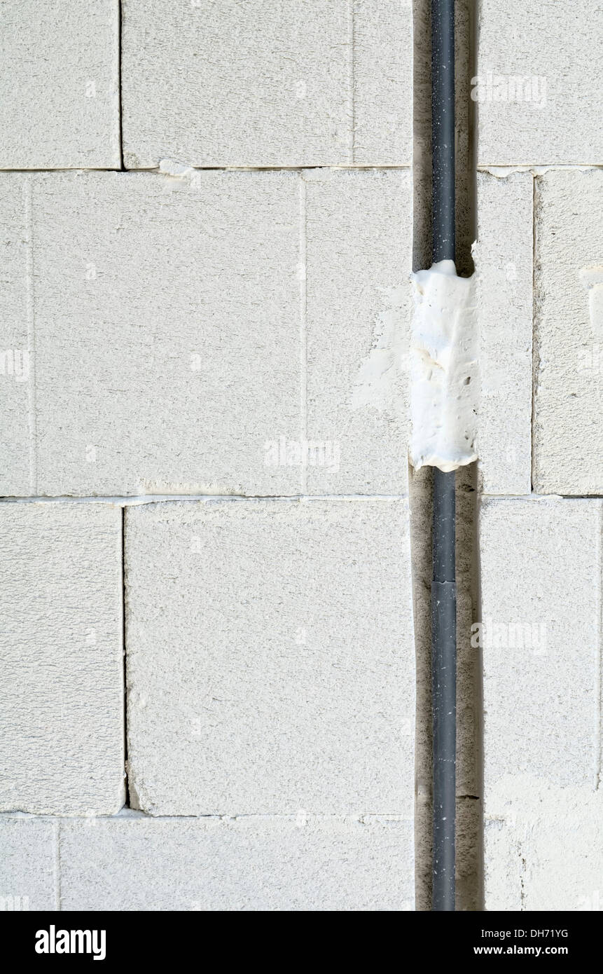 Cable eléctrico aislado tallado en pared vertical Foto de stock
