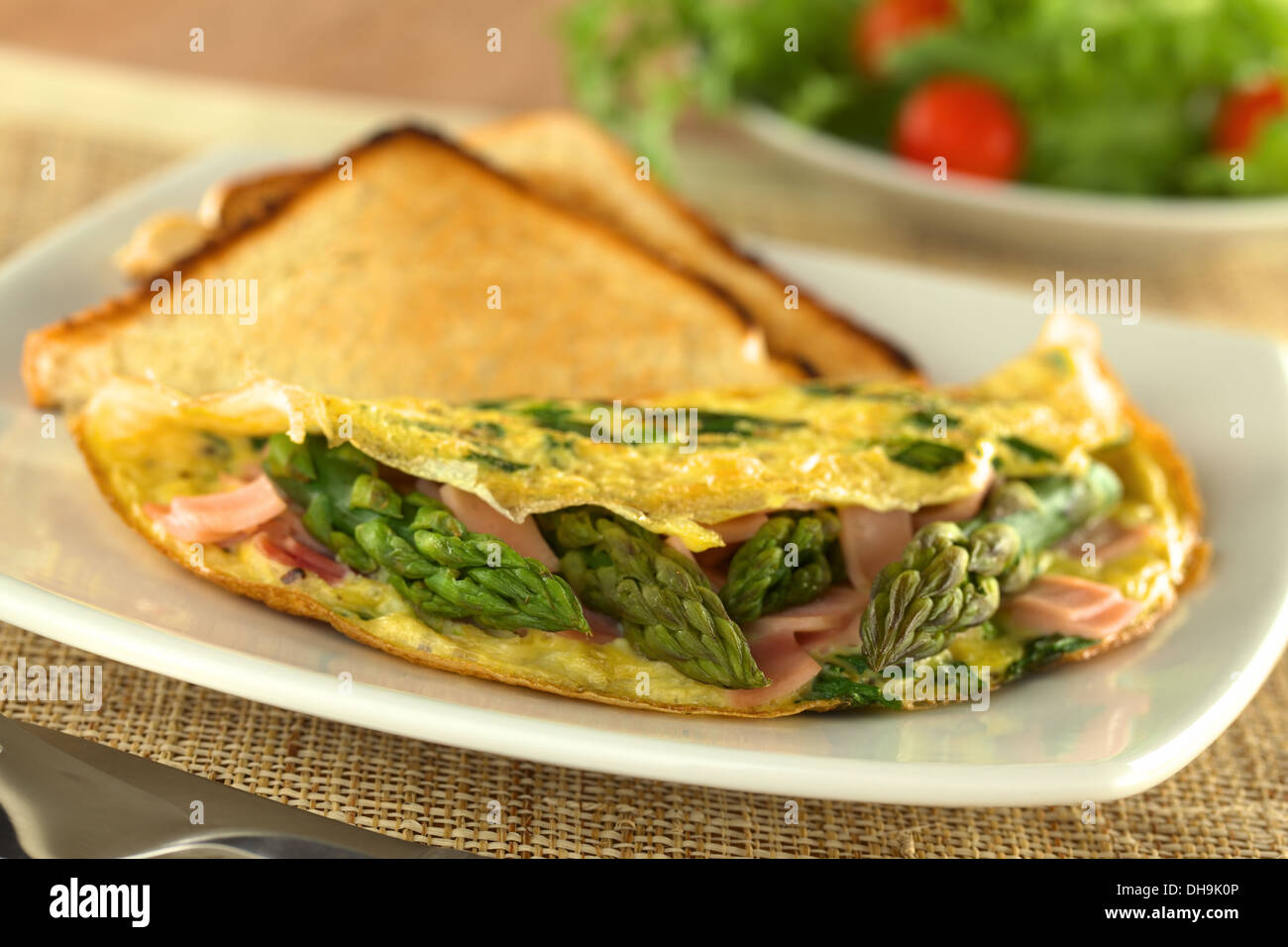 Los espárragos verdes y jamón tortilla de huevos con tostadas de pan y