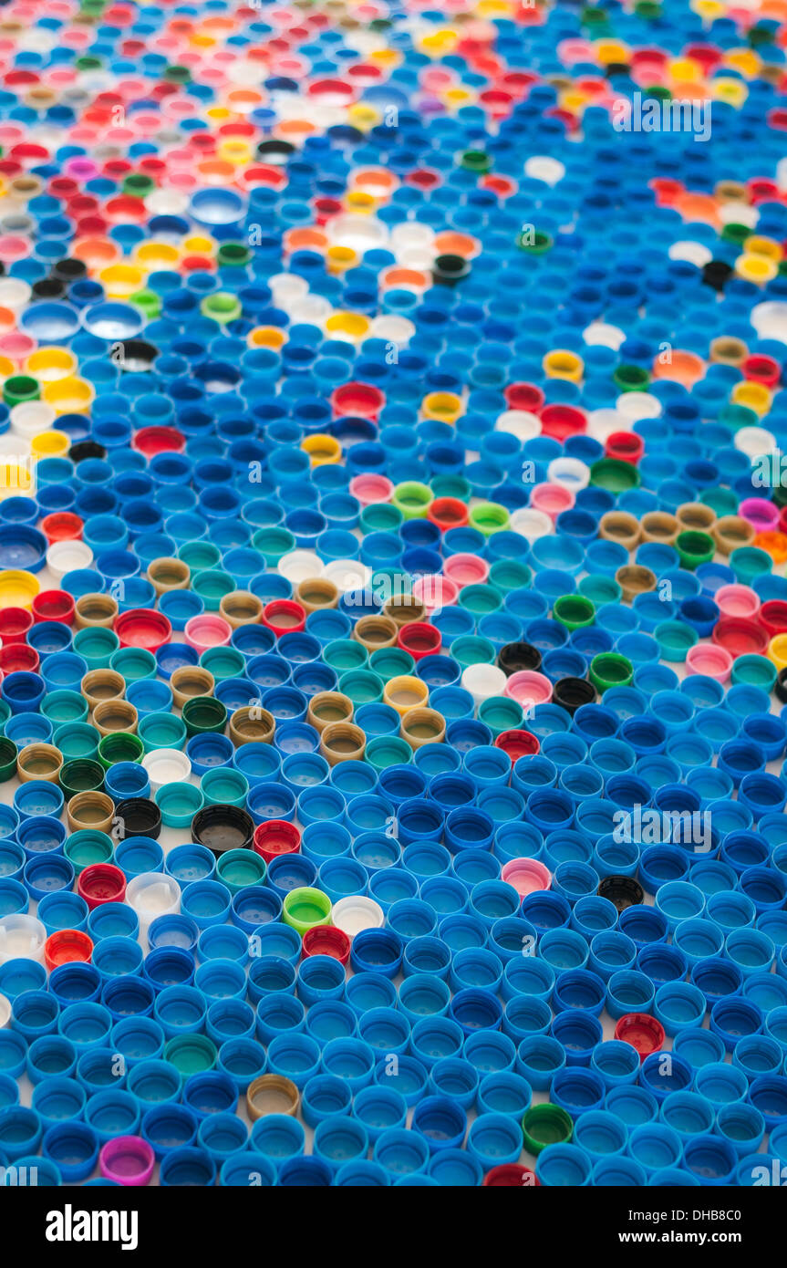 Las tapas de las botellas de plástico de colores en una fila Foto de stock