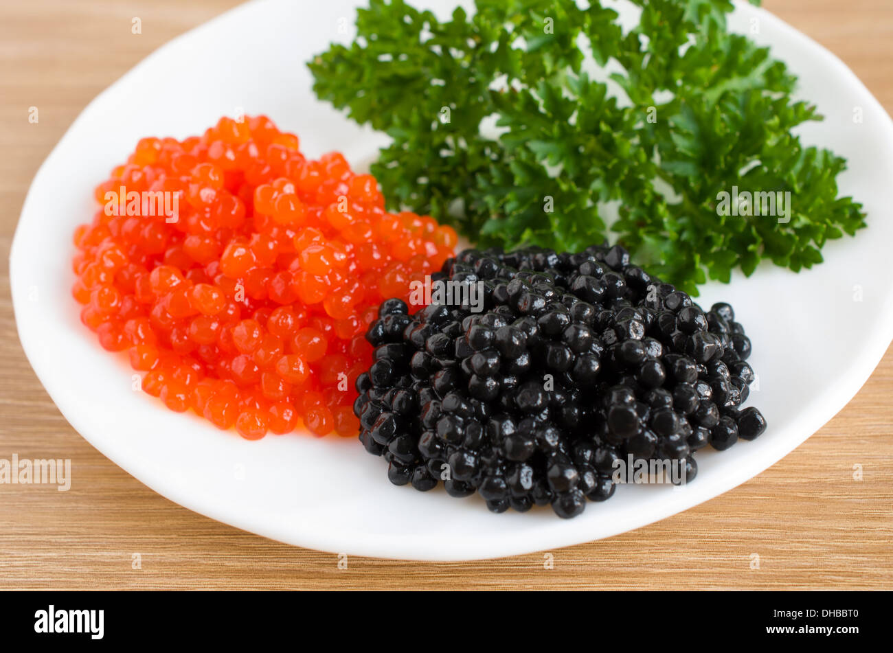 Caviar rojo y negro en un plato para servir Foto de stock