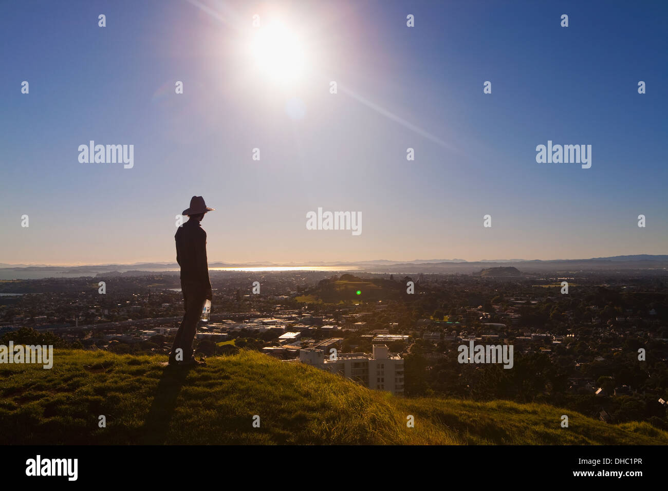 Silueta de un hombre en un sombrero de pie en Mt. Eden con vistas de Auckland, Nueva Zelanda Foto de stock