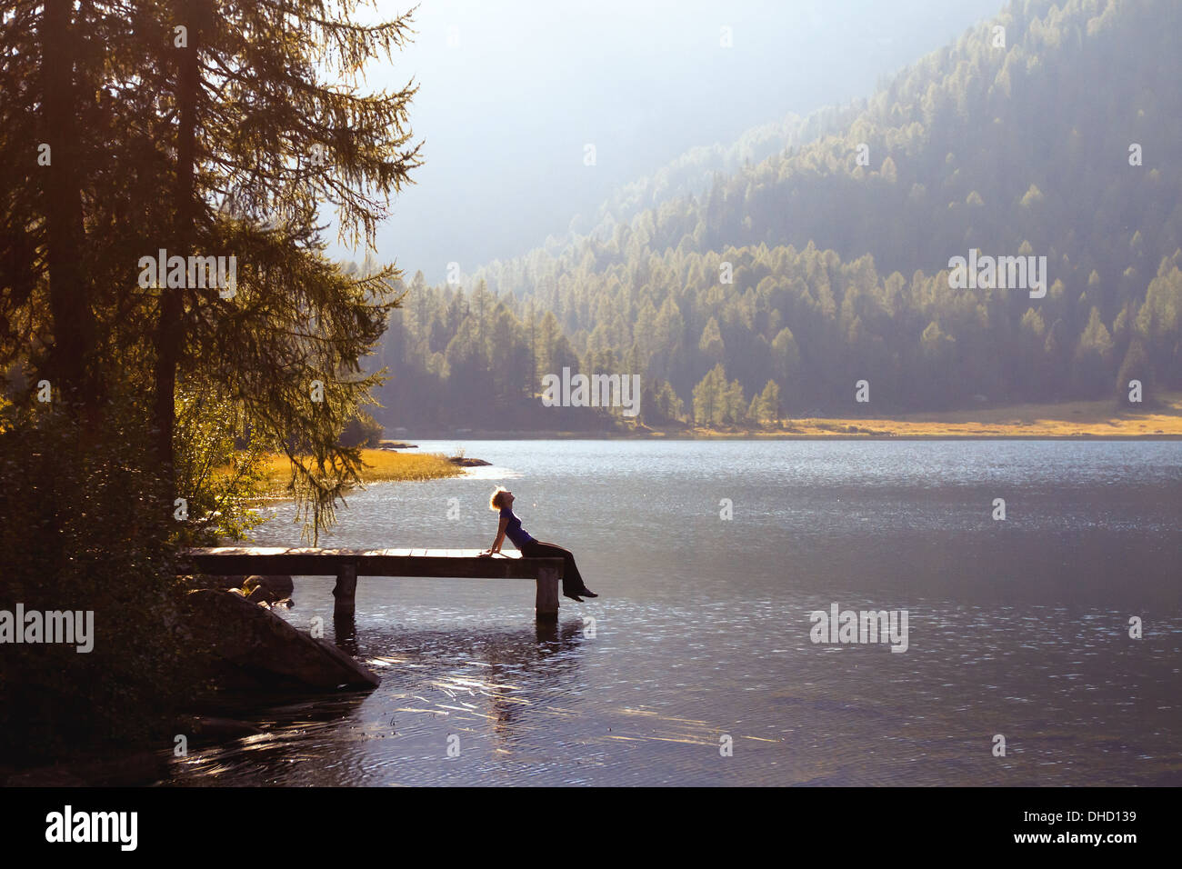 Mujer joven para disfrutar de la naturaleza en el lago de montaña Foto de stock