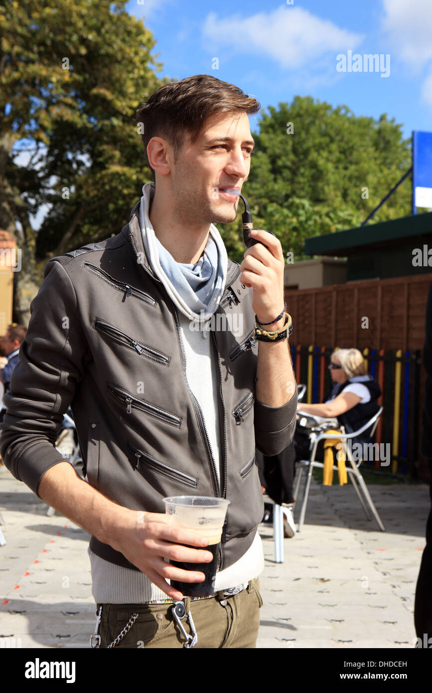 Extraños en 2013, un hombre joven relajante a fumar en pipa y tomar una cerveza Foto de stock