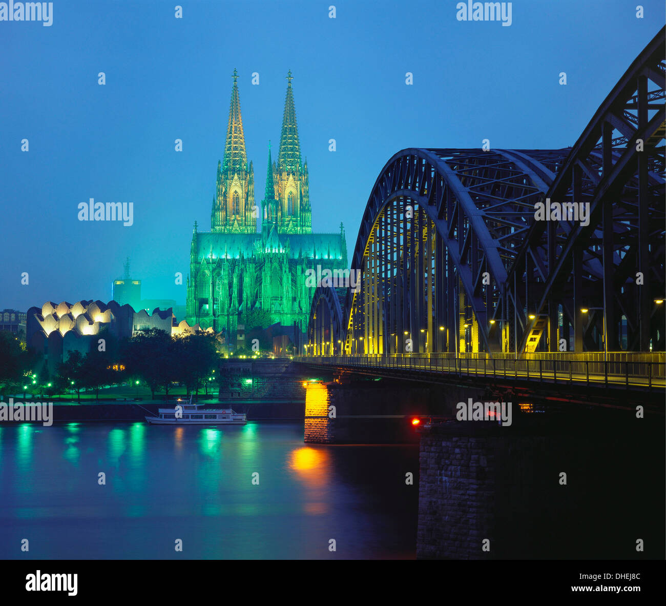 Hohenzollernbrucke y la Catedral iluminada por la noche, en Colonia, Alemania Foto de stock