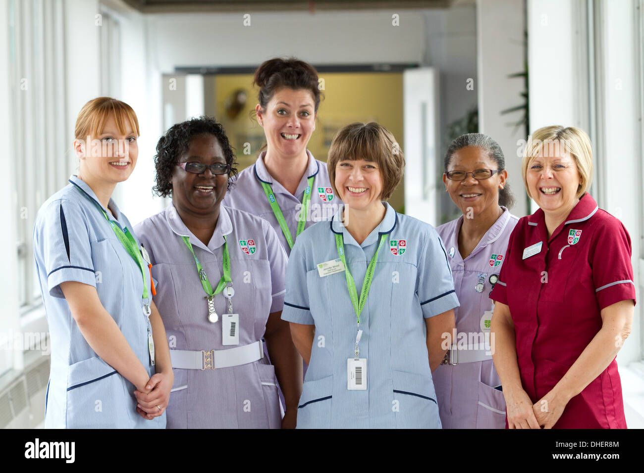 Un grupo de 5 enfermeras sonrisa hacia la cámara en un corredor de hospital UK Foto de stock