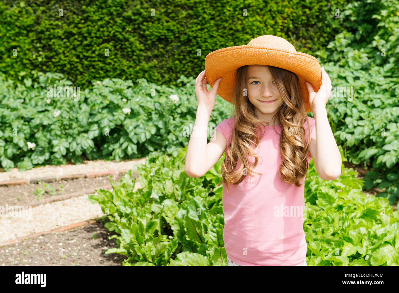 Vestida de sombrero de paja en el jardín Foto de stock
