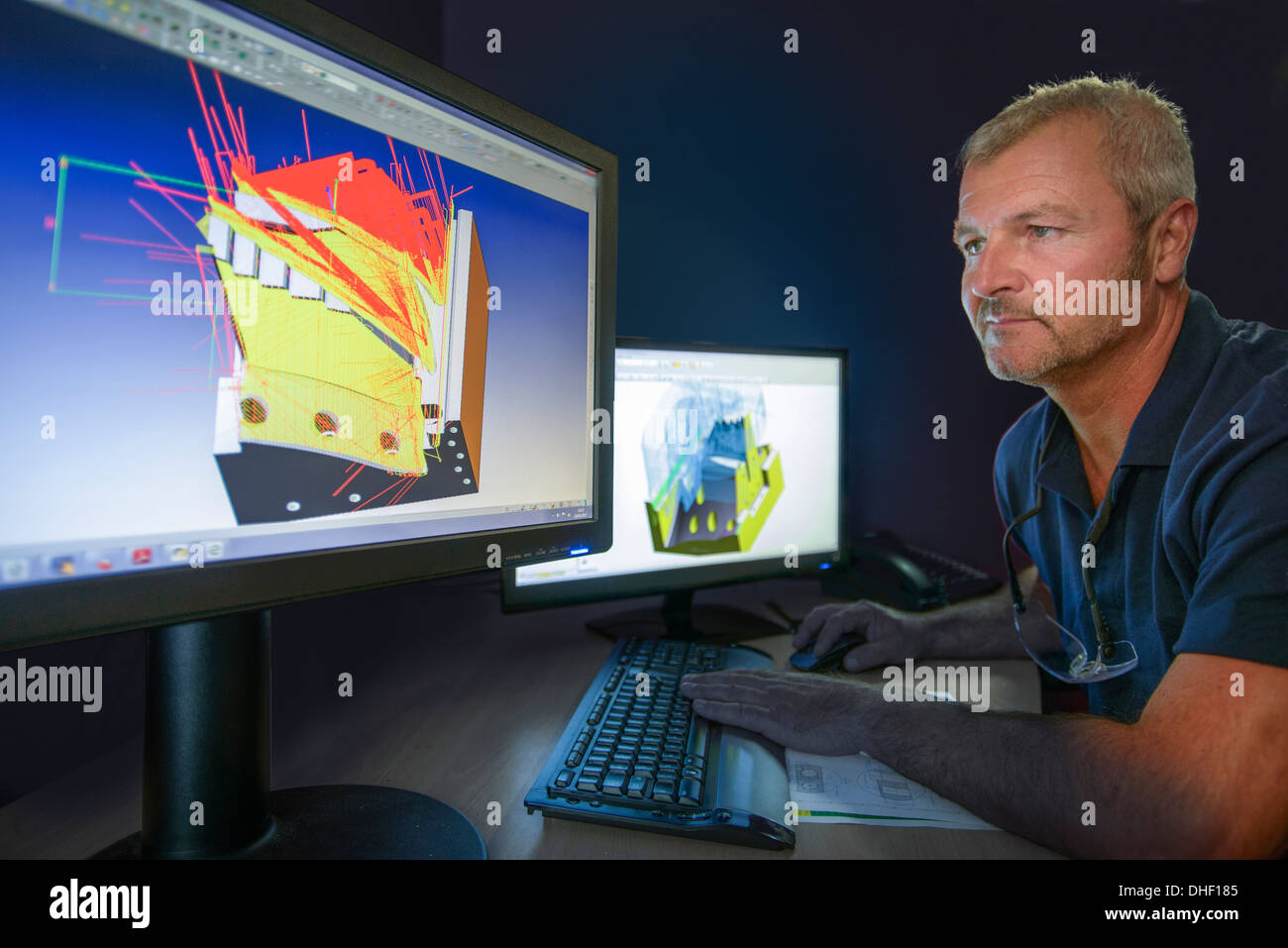 Ingeniero mirando monitor de ordenador con diagramas de diseño asistido por ordenador Foto de stock