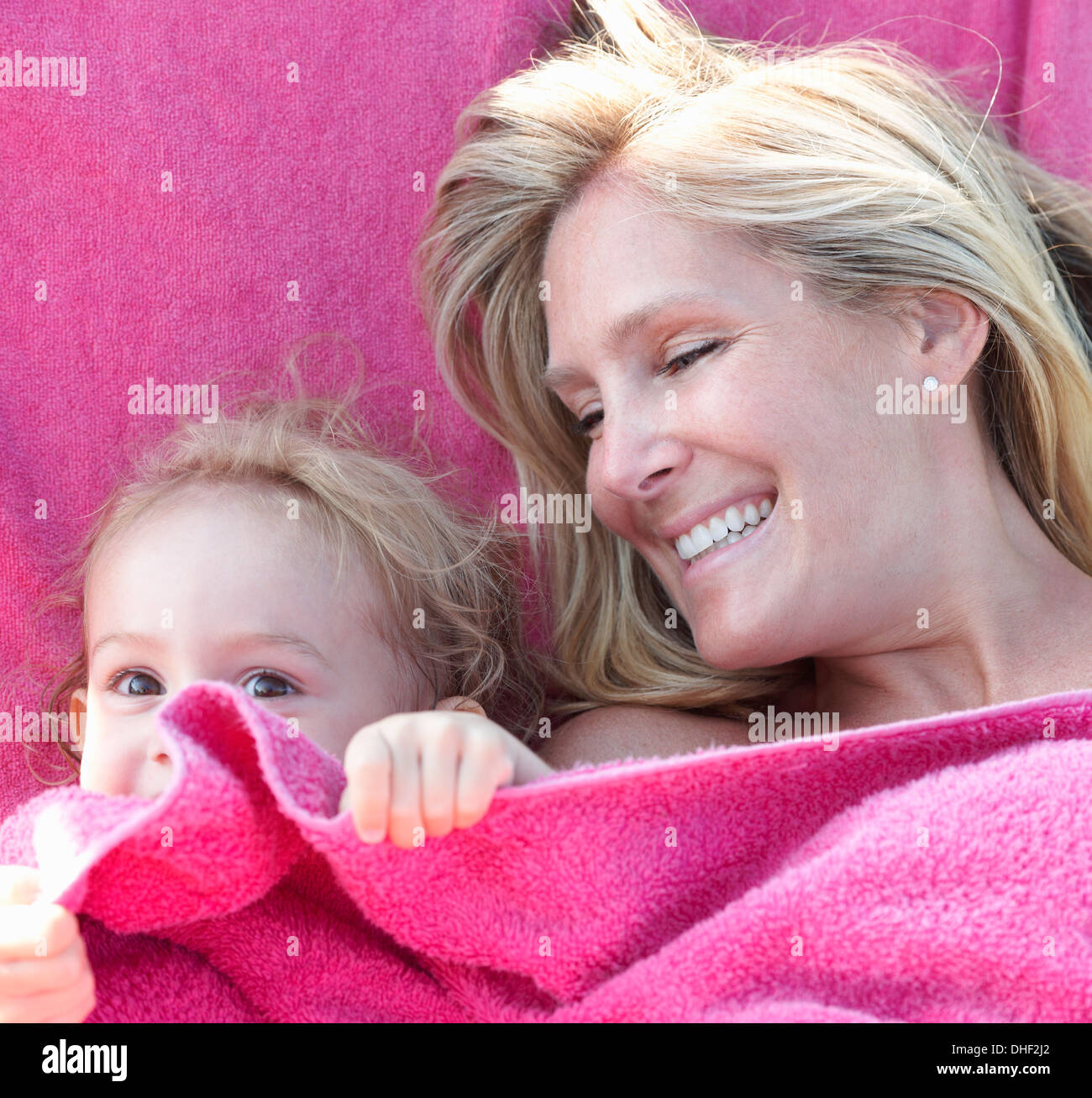 Retrato de madre e hija envuelta en una toalla rosa Foto de stock