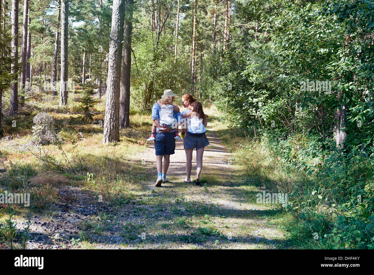Los padres dando hijas concatenada a través del bosque Foto de stock